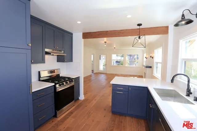a kitchen with granite countertop a sink cabinets and wooden floor