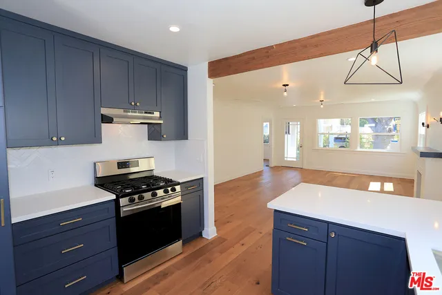 a kitchen with granite countertop a stove a sink and a refrigerator