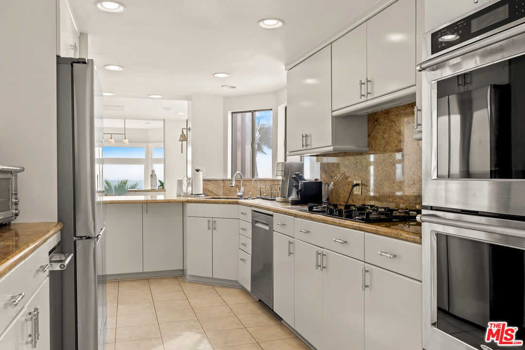 3616 The Strand, Unit C Manhattan Beach, CA 90266 - Photo 13 of 34 a kitchen with white cabinets and appliances