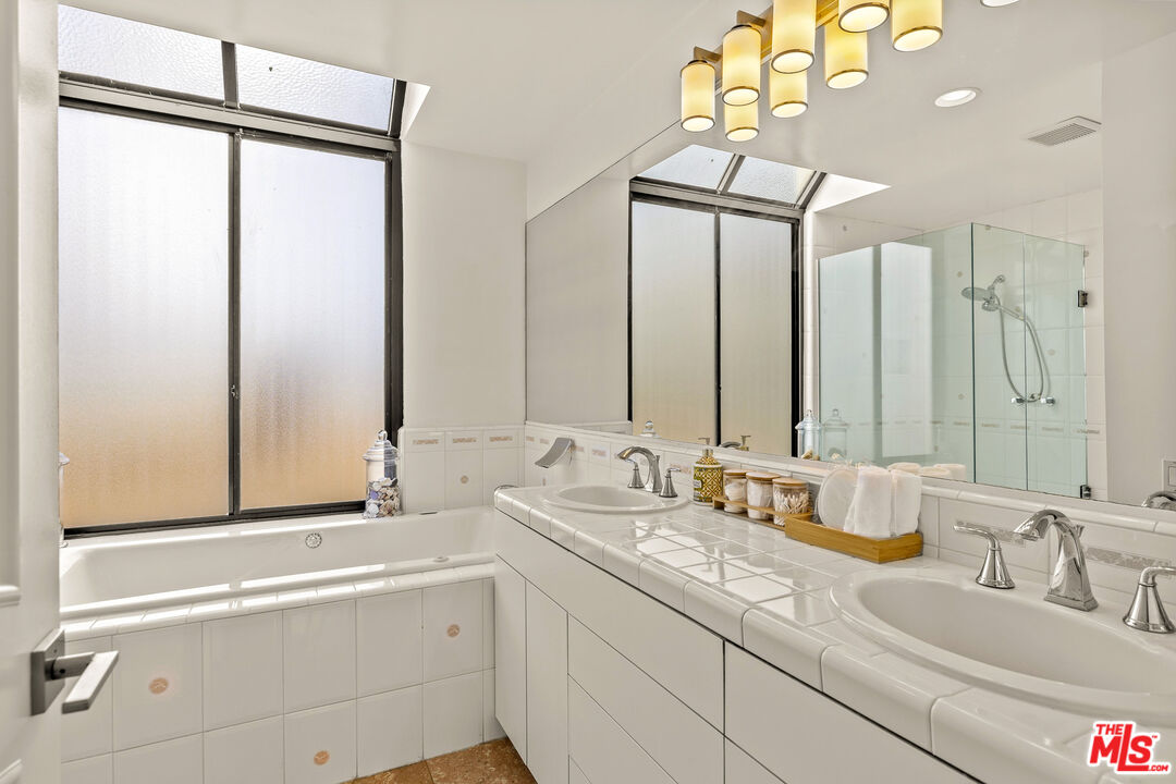 3616 The Strand, Unit C Manhattan Beach, CA 90266 - Photo 17 of 34 a bathroom with a double vanity sink and mirror with bathtub