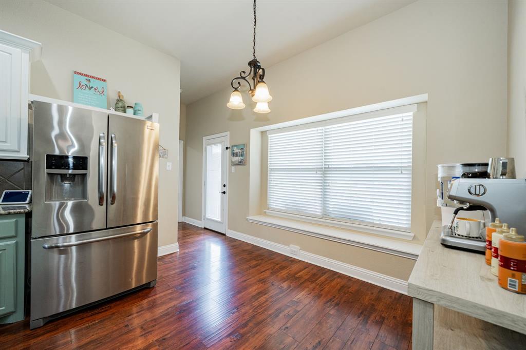 14176 Paterson Road Talty, TX 75126 - Photo 11 of 40 a kitchen with stainless steel appliances wooden floor and large window