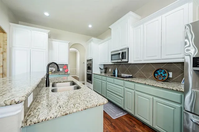a kitchen with stainless steel appliances granite countertop a sink a stove and a microwave