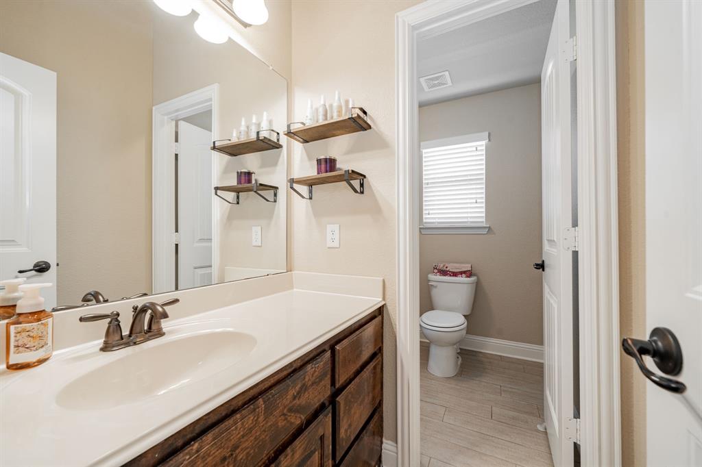 14176 Paterson Road Talty, TX 75126 - Photo 25 of 40 a bathroom with a sink a toilet and a mirror