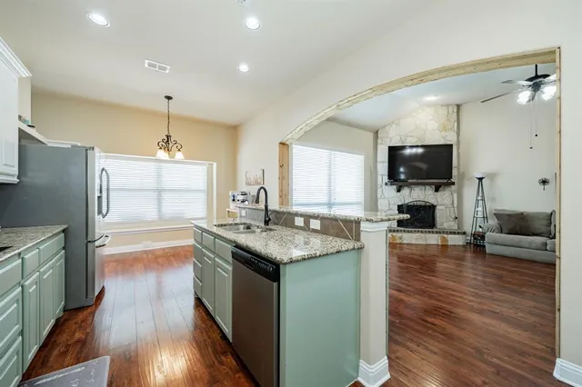 a kitchen with granite countertop counter top space a sink stainless steel appliances and cabinets