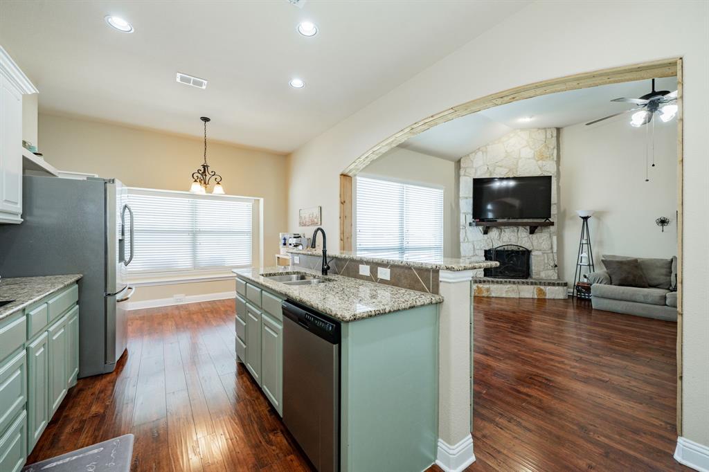 14176 Paterson Road Talty, TX 75126 - Photo 7 of 40 a kitchen with granite countertop counter top space a sink stainless steel appliances and cabinets
