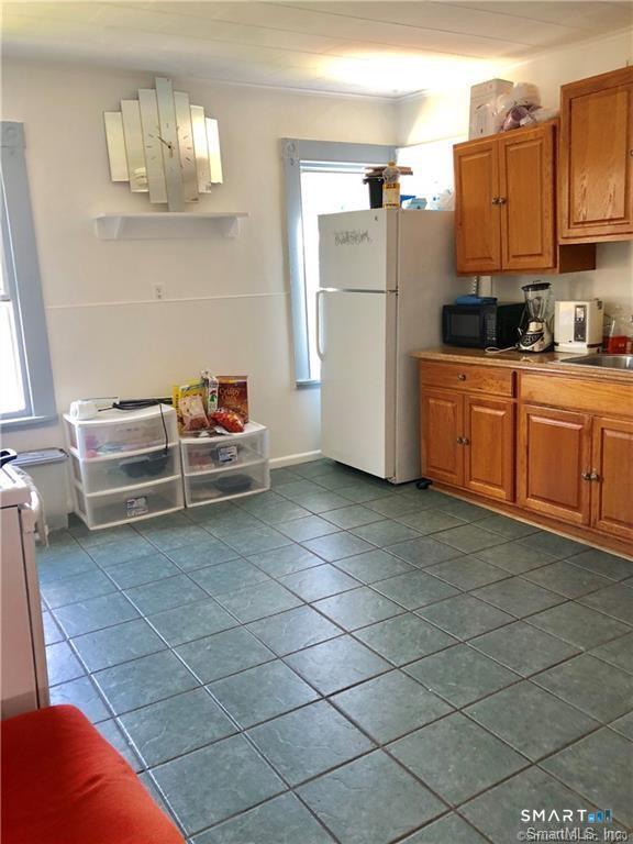 110 Beaver Street Ansonia, CT 06401 - Photo 15 of 31 a kitchen with a sink a refrigerator and cabinets