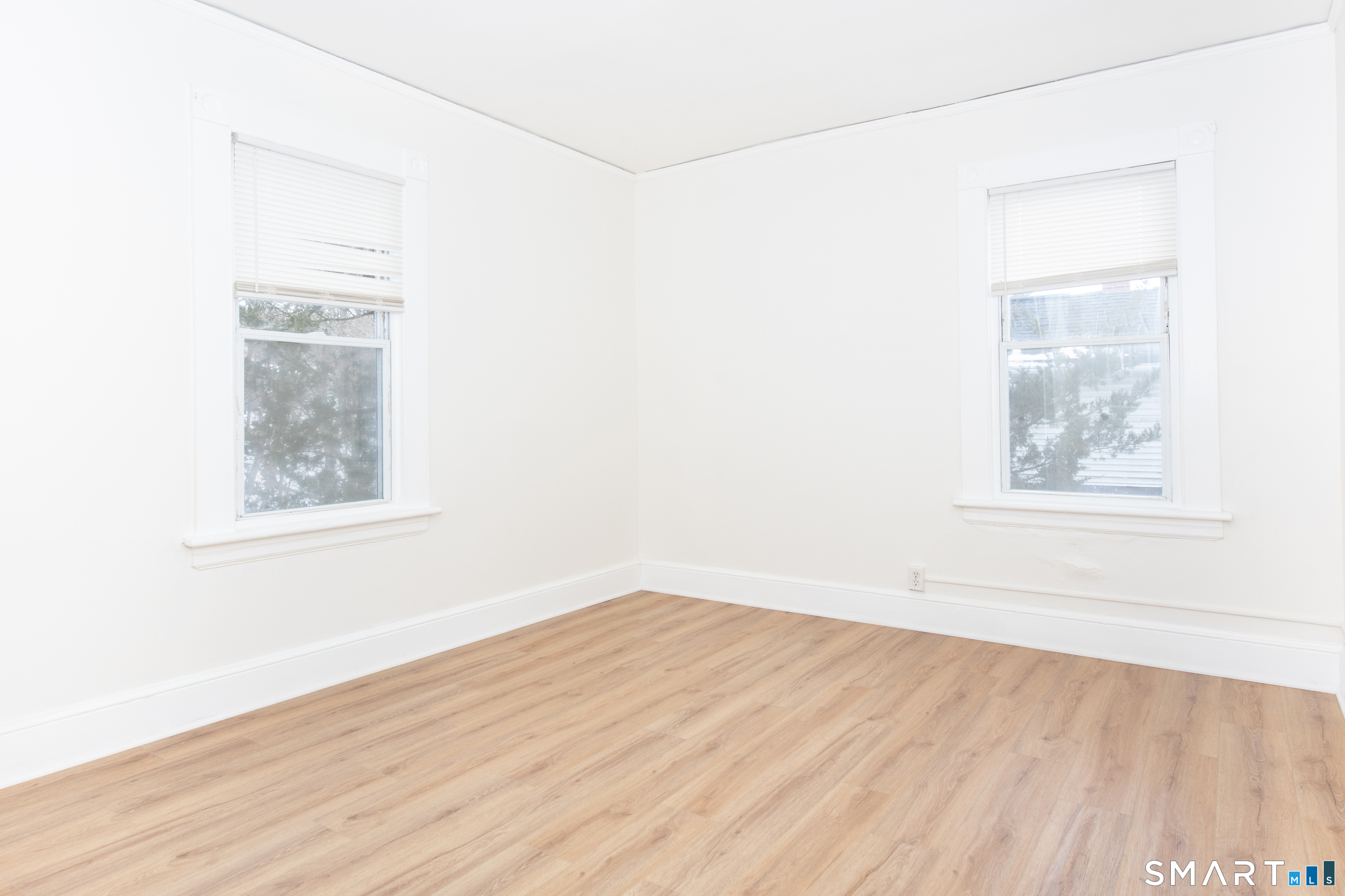 110 Beaver Street Ansonia, CT 06401 - Photo 9 of 31 an empty room with wooden floor and windows