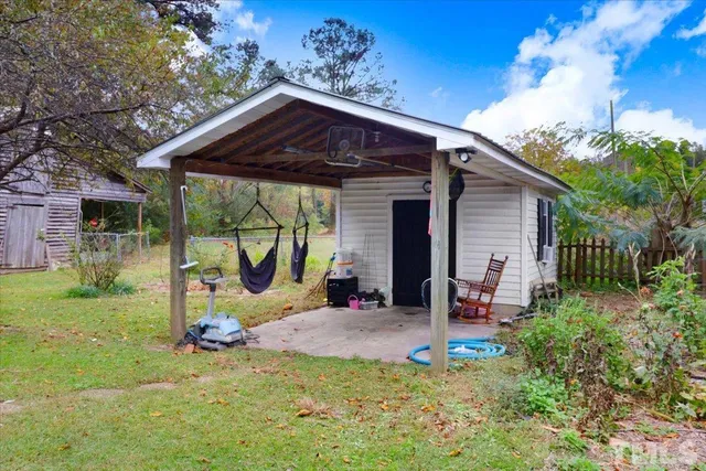 a view of a chair and table in backyard of the house