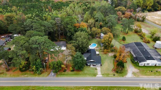 an aerial view of a residential houses with yard and swimming pool