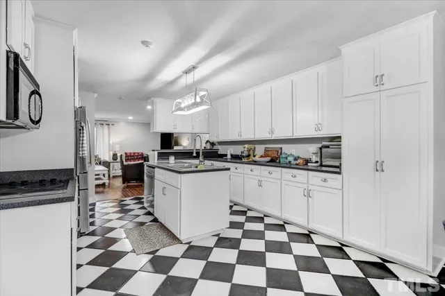 a kitchen with a checkered floor and white cabinets