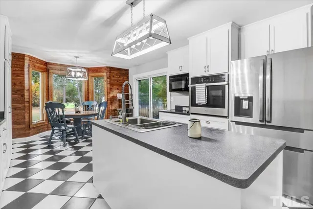 a kitchen with stainless steel appliances granite countertop a sink a stove and refrigerator