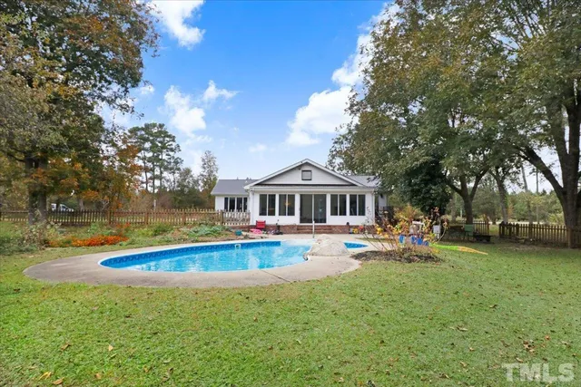 a view of a house with swimming pool and sitting area