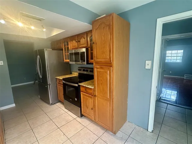 a kitchen with stainless steel appliances granite countertop a refrigerator and a stove