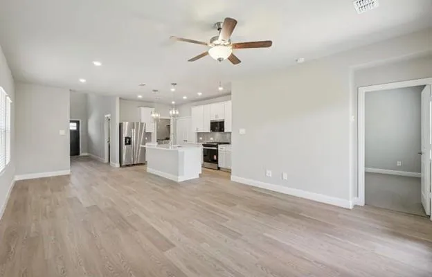 a view of an empty room with a kitchen