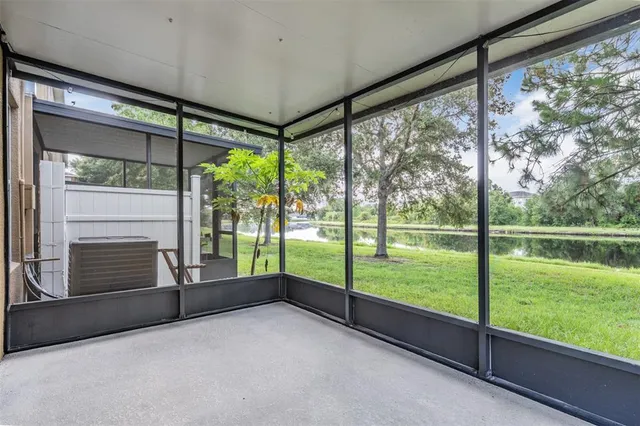 a view of an empty room with floor to ceiling windows and garden