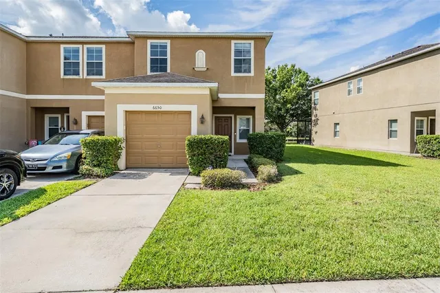 a front view of a house with a yard and garage
