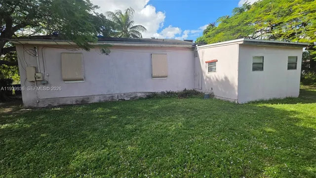 a view of a backyard with barn plants and large tree