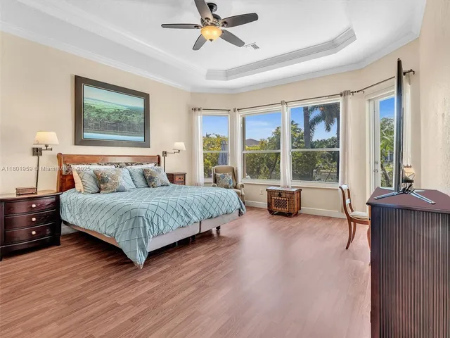 a bedroom with a bed and a flat screen tv with wooden floor