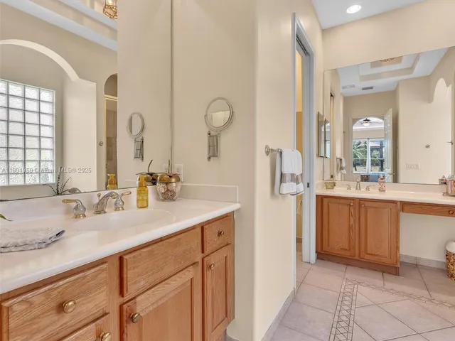 a bathroom with a tub a double vanity sink and mirror