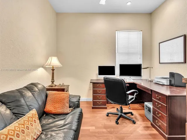 a view of a workspace with furniture and wooden floor