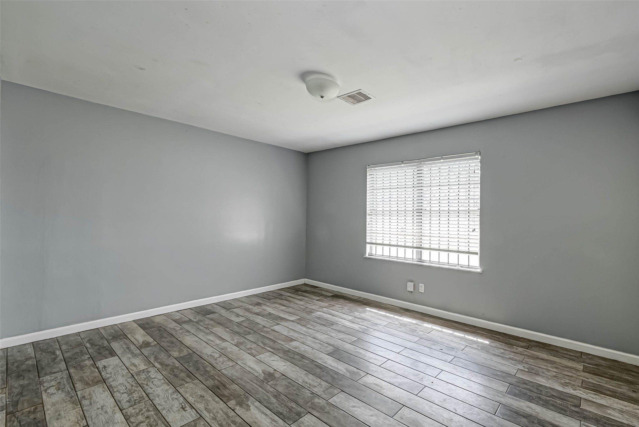 4821 Alvin Street Houston, TX 77033 - Photo 3 of 15 wooden floor in an empty room with a window