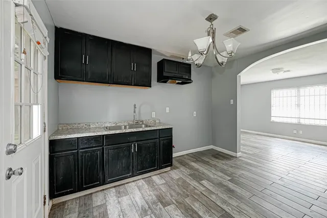 a kitchen with stainless steel appliances granite countertop a sink dishwasher a stove and a refrigerator with wooden floor