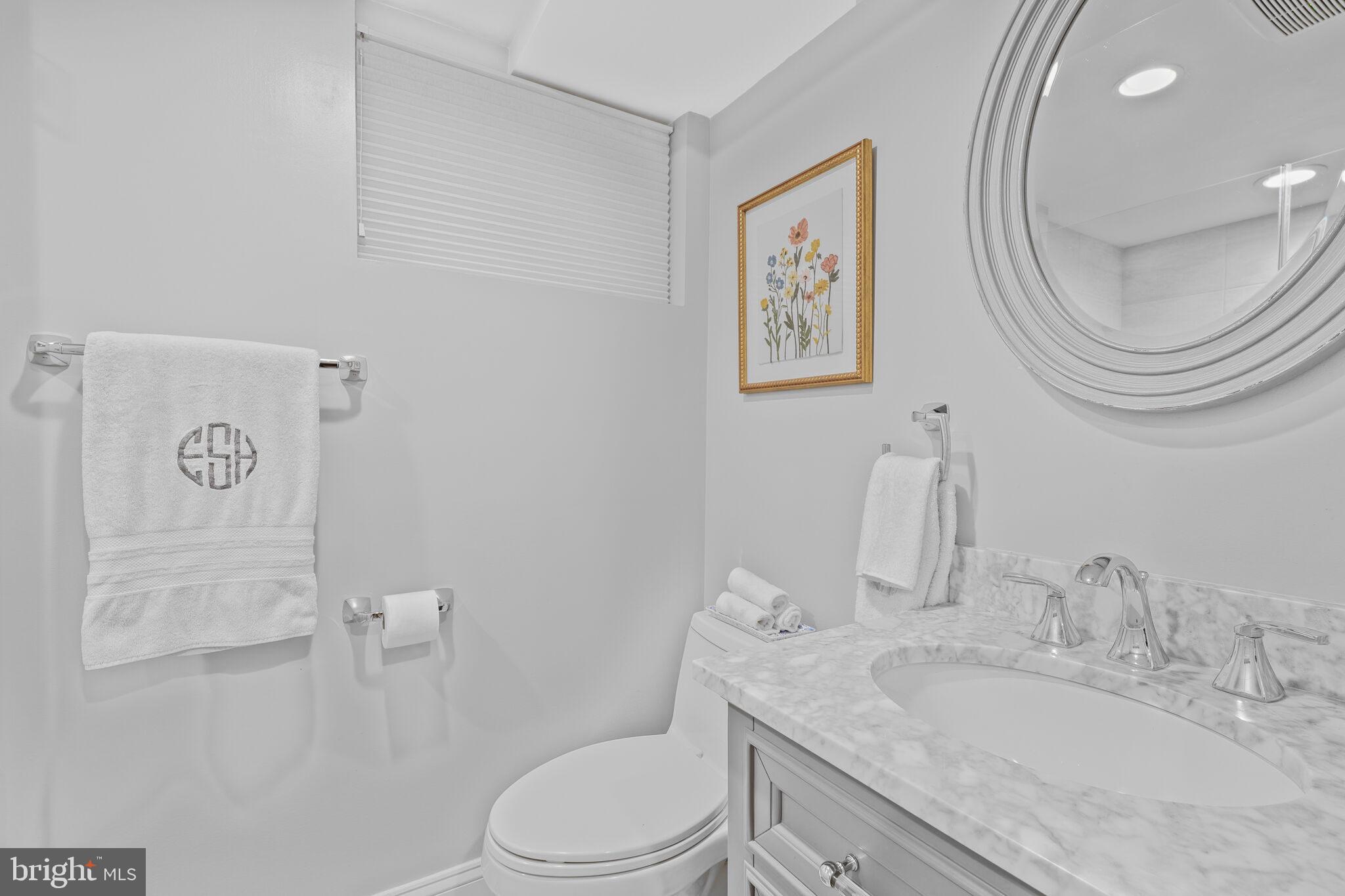 5442 Broad Branch Road Northwest Washington, DC 20015 - Photo 25 of 28 a bathroom with a granite countertop toilet a sink and a mirror