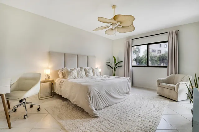 a spacious bedroom with a bed and a flat screen tv