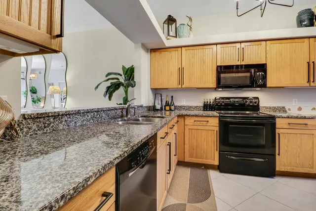 a kitchen with stainless steel appliances granite countertop a refrigerator and a sink