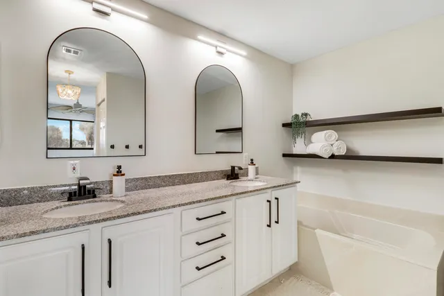 a bathroom with a granite countertop sink a toilet and vanity