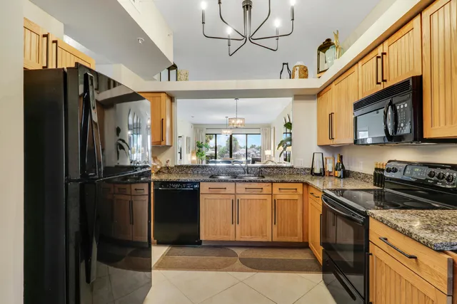 a kitchen with granite countertop a sink a stove cabinets and counter space
