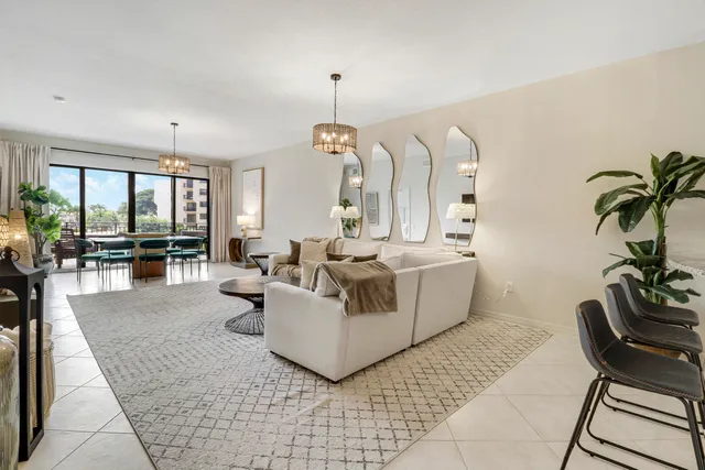 a living room with furniture chandelier and a large window