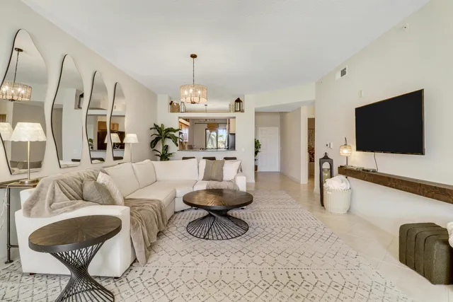 a living room with furniture flat screen tv and a large window