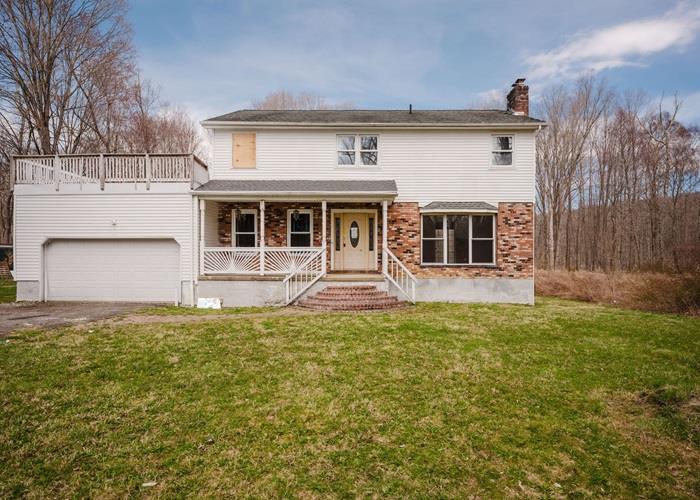 27 Nathan Hale Drive Stormville, NY 12582 - Photo 1 of 22 Traditional-style house with covered porch, a chimney, a front yard, driveway, and an attached garage