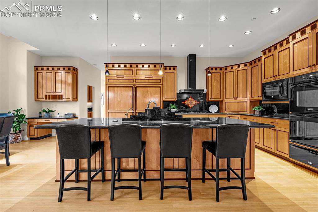 205 Cobblestone Way Monument, CO 80132 - Photo 11 of 45 a kitchen with stainless steel appliances kitchen island granite countertop a stove a sink a oven a dining table and chairs