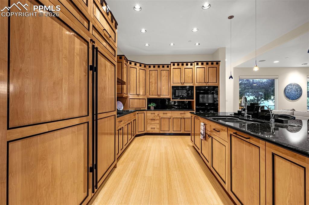 205 Cobblestone Way Monument, CO 80132 - Photo 13 of 45 a large kitchen with stainless steel appliances a refrigerator a sink and wooden cabinets
