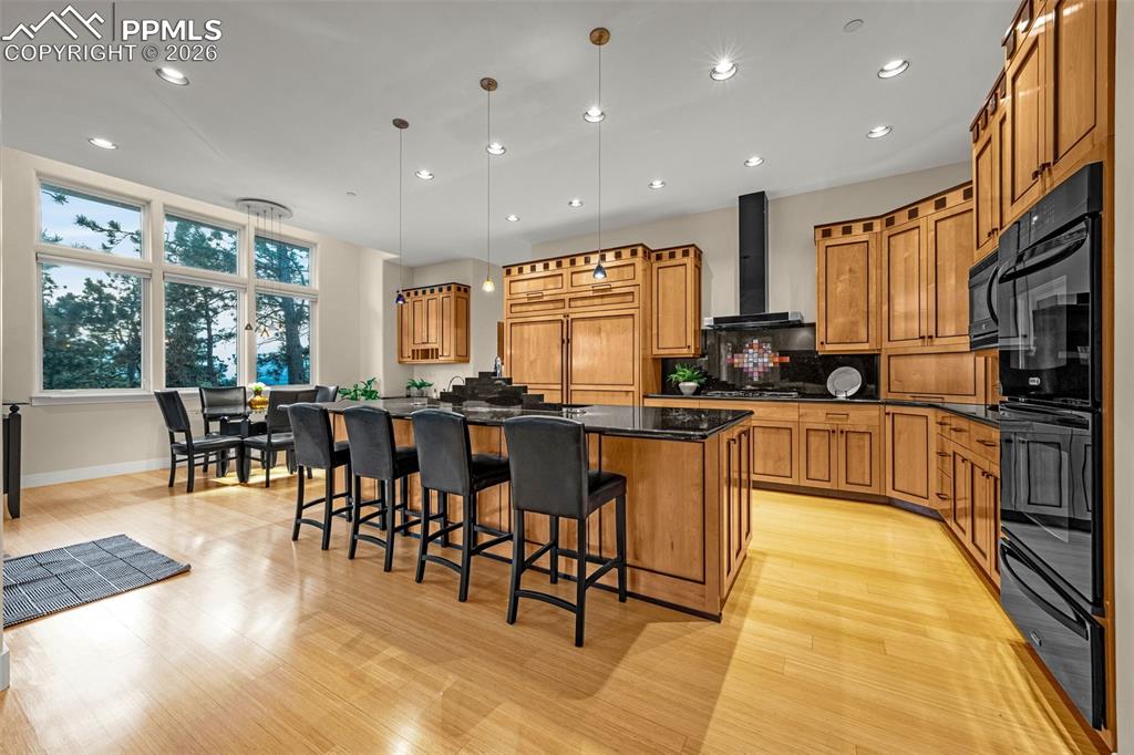 205 Cobblestone Way Monument, CO 80132 - Photo 10 of 45 a kitchen with stainless steel appliances kitchen island granite countertop a stove a sink a dining table and chairs