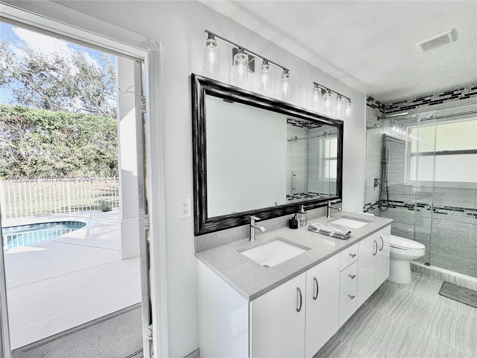 19754 Dinner Key Drive Boca Raton, FL 33498 - Photo 20 of 48 a bathroom with a sink double vanity and a mirror