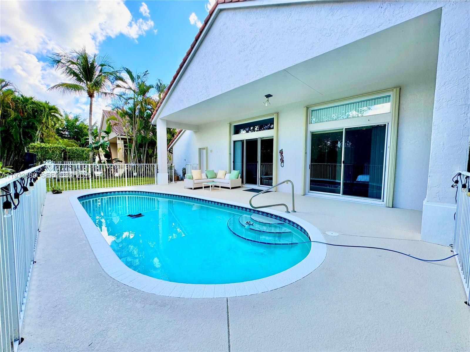 19754 Dinner Key Drive Boca Raton, FL 33498 - Photo 23 of 48 a view of a swimming pool with chairs