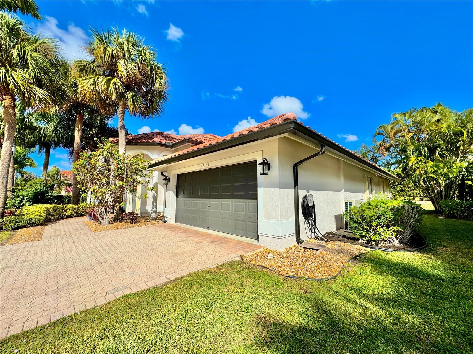 19754 Dinner Key Drive Boca Raton, FL 33498 - Photo 32 of 48 a front view of a house with a yard and garage