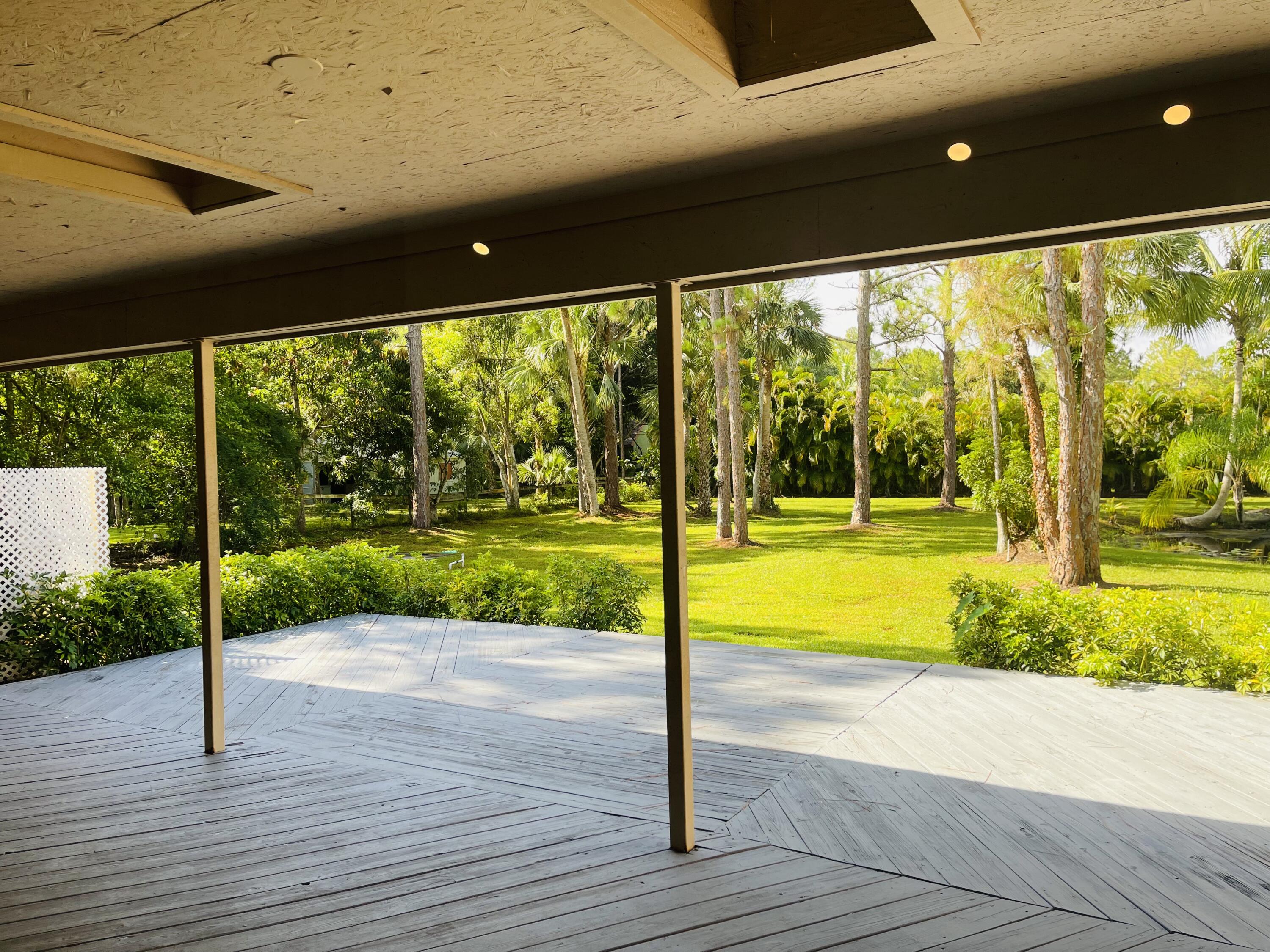 9296 166th Way North Jupiter, FL 33478 - Photo 16 of 31 a view of a porch and garden