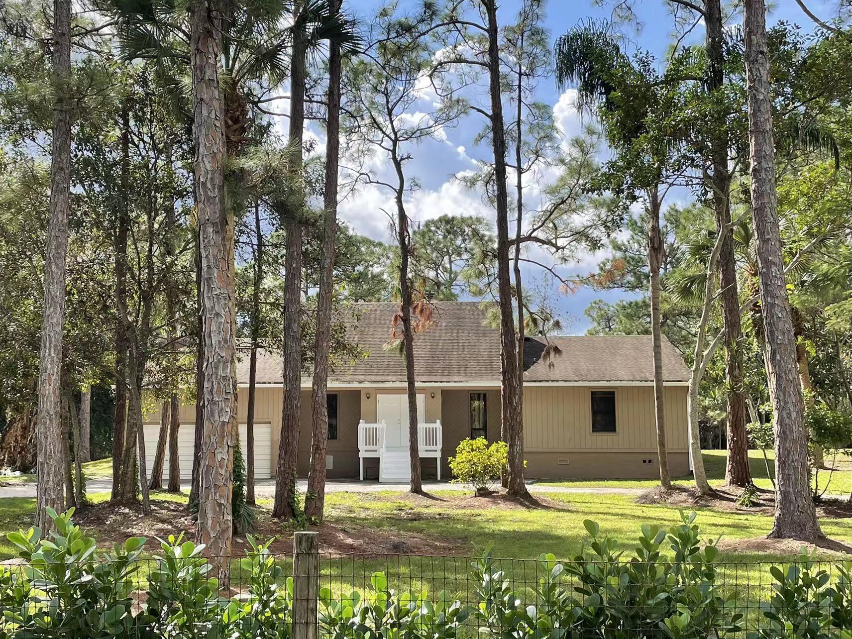 9296 166th Way North Jupiter, FL 33478 - Photo 2 of 31 a view of swimming pool with outdoor seating and covered with trees