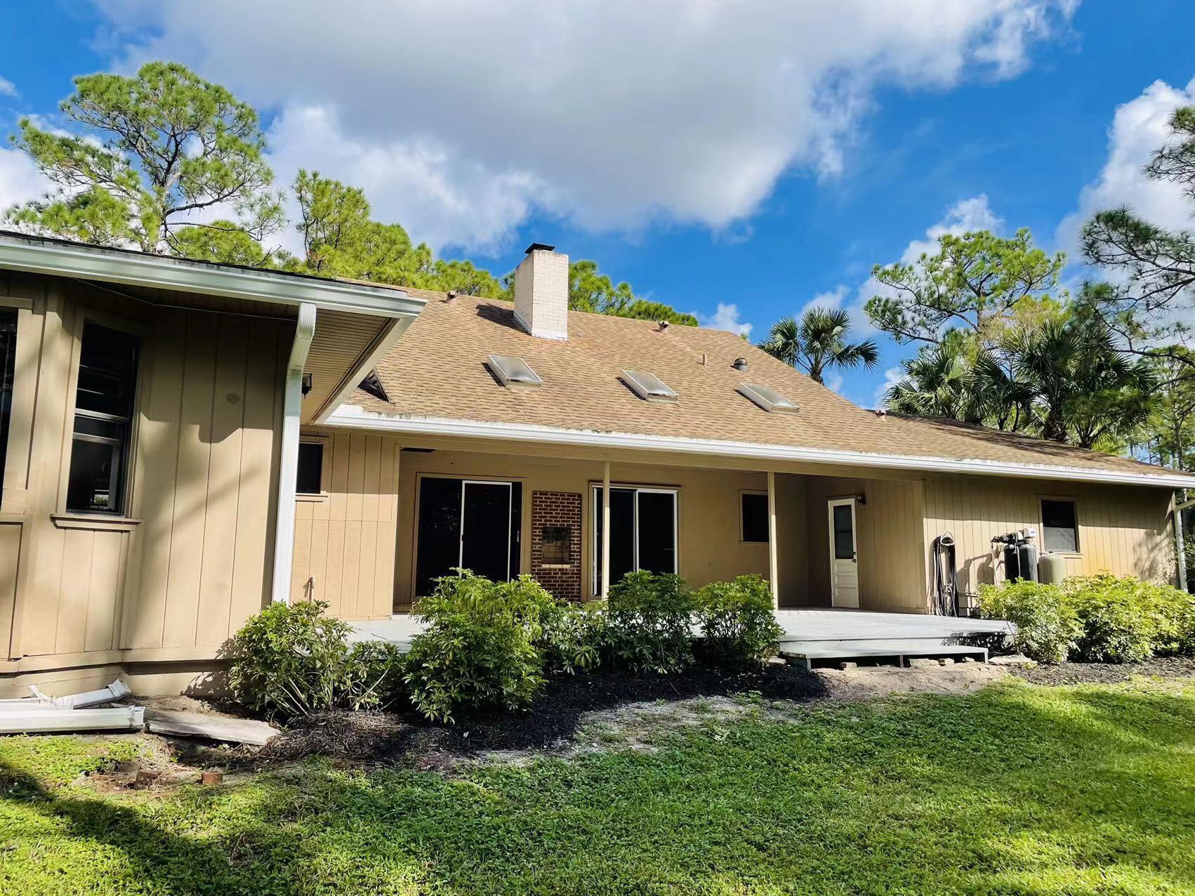 9296 166th Way North Jupiter, FL 33478 - Photo 24 of 31 a front view of a house with a garden