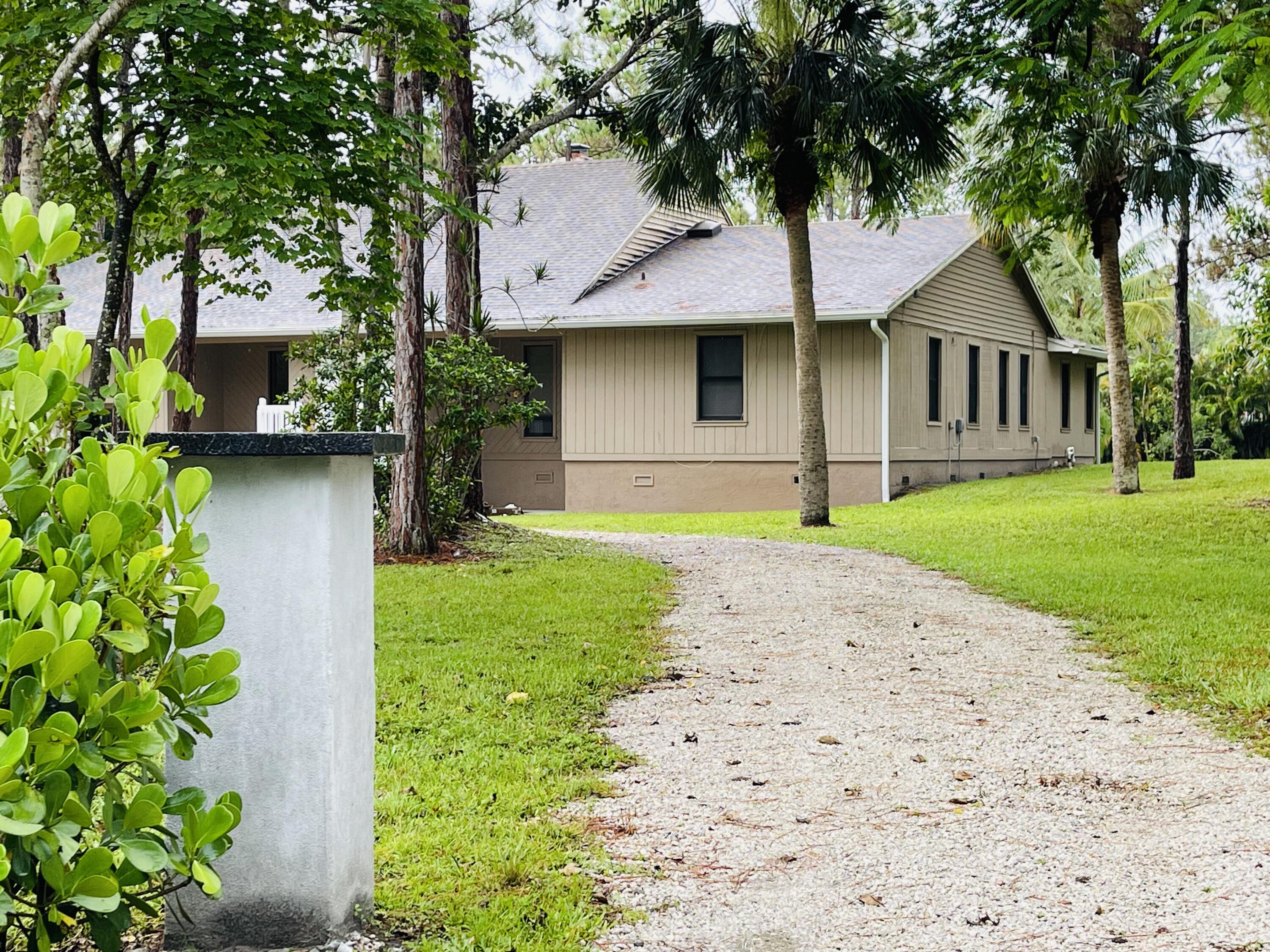 9296 166th Way North Jupiter, FL 33478 - Photo 4 of 31 a front view of a house with a garden and yard