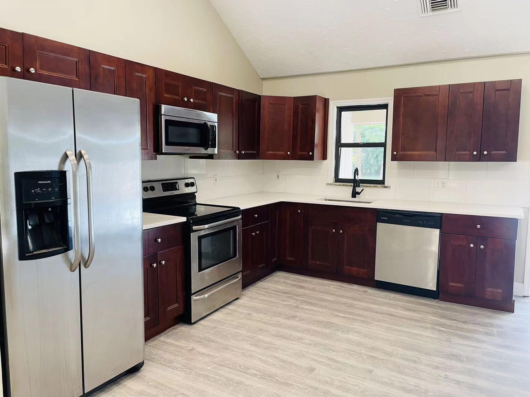 9296 166th Way North Jupiter, FL 33478 - Photo 8 of 31 a kitchen with stainless steel appliances granite countertop a stove a sink dishwasher a refrigerator and a microwave oven