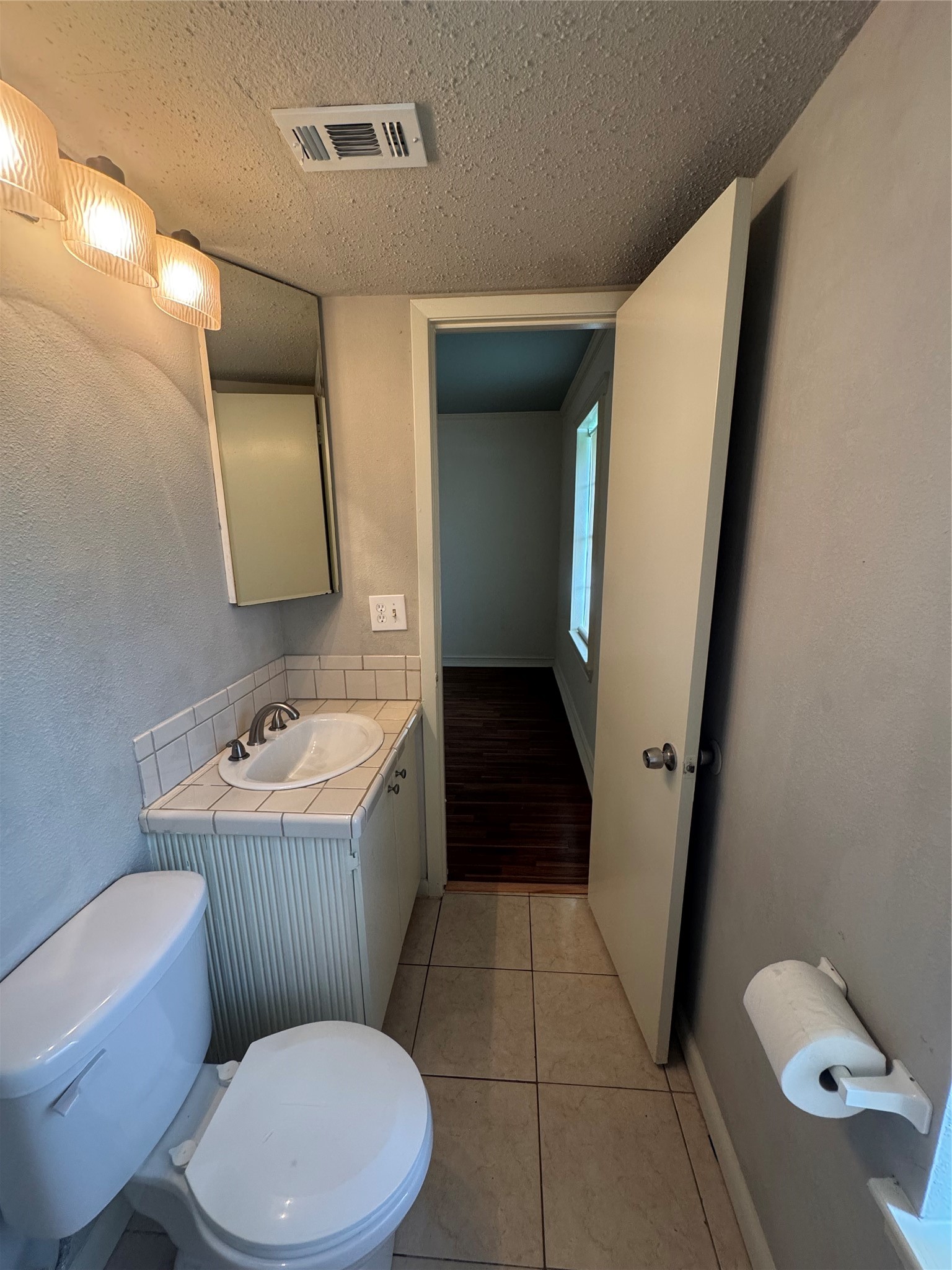 1443 Willow Rock Road Houston, TX 77088 - Photo 25 of 27 a bathroom with a sink a toilet a mirror and bathtub