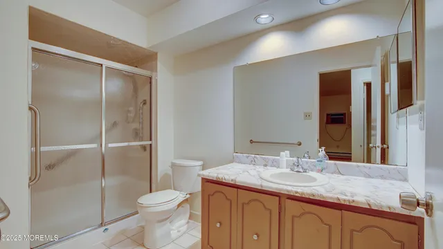 a bathroom with a granite countertop sink toilet and shower
