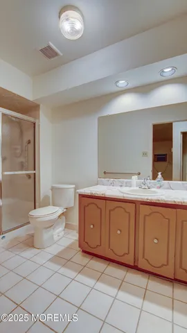 a bathroom with a granite countertop sink and a toilet