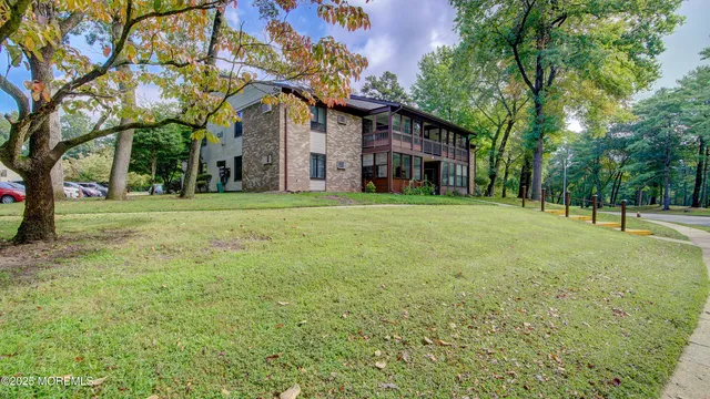 a view of a big house with a big yard and large trees