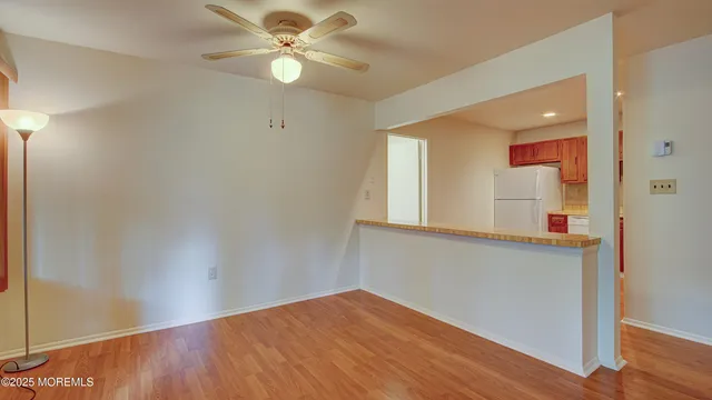a view of a kitchen with wooden floor and a ceiling fan